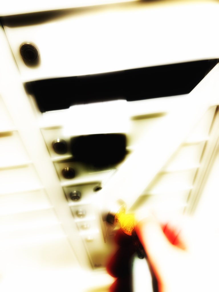 Fuzzy photo of an envelope partly jutting out of a short, wide post office box.